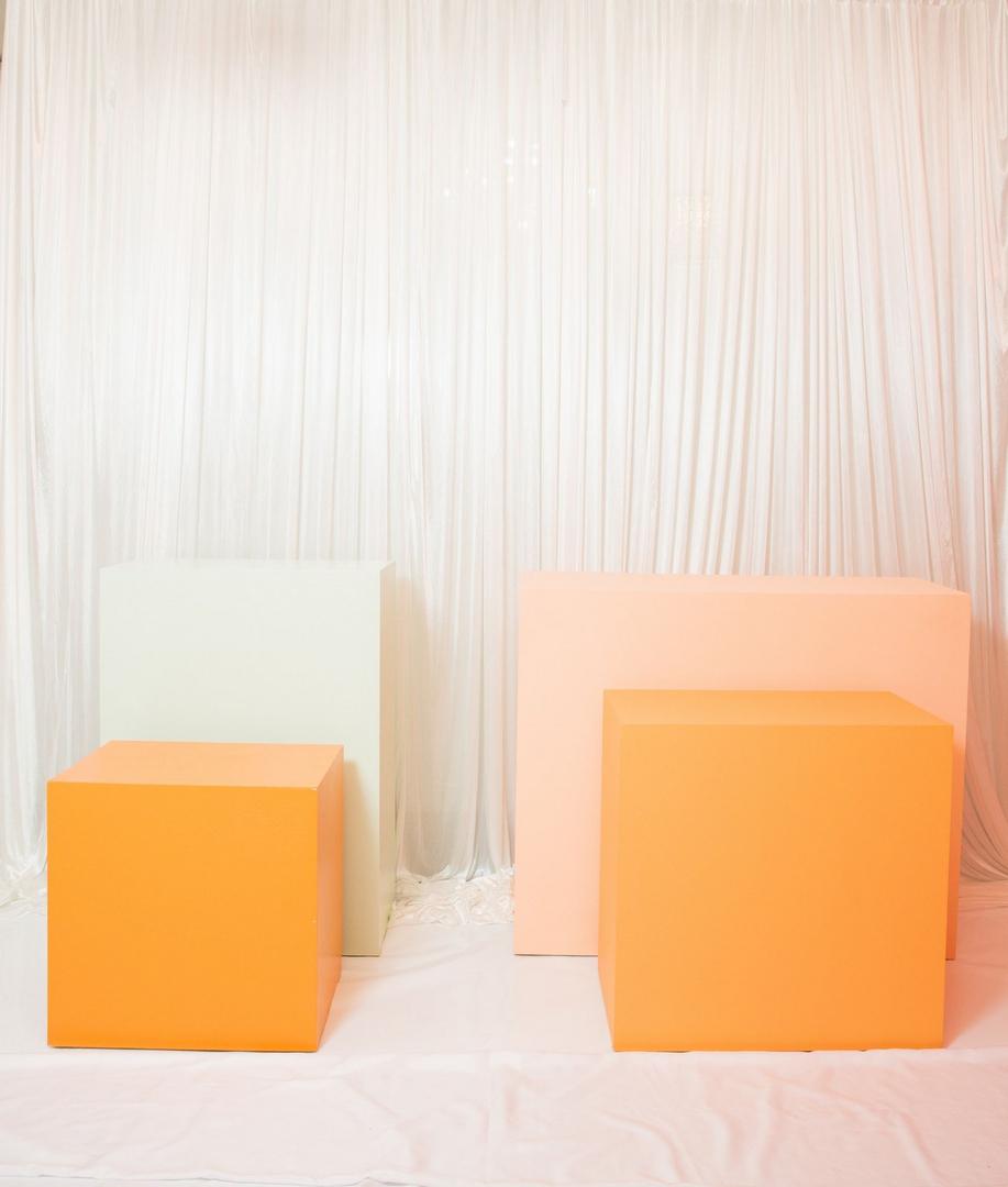 Two orange and white cubes on a table