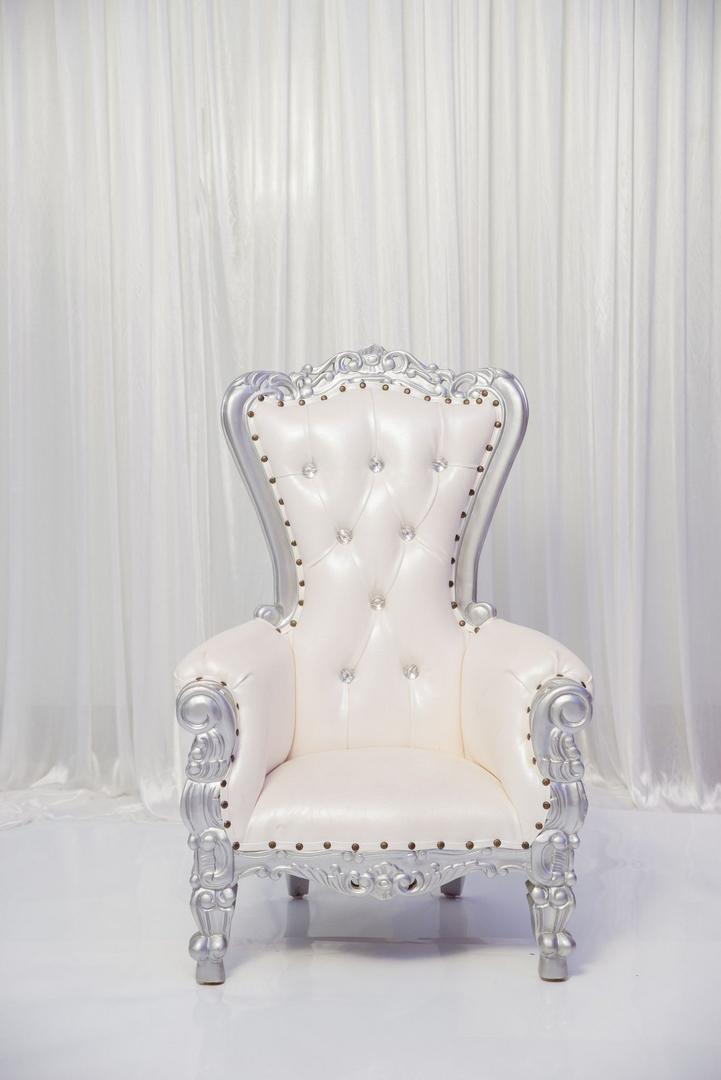 A white chair with silver trim and a diamond pattern.