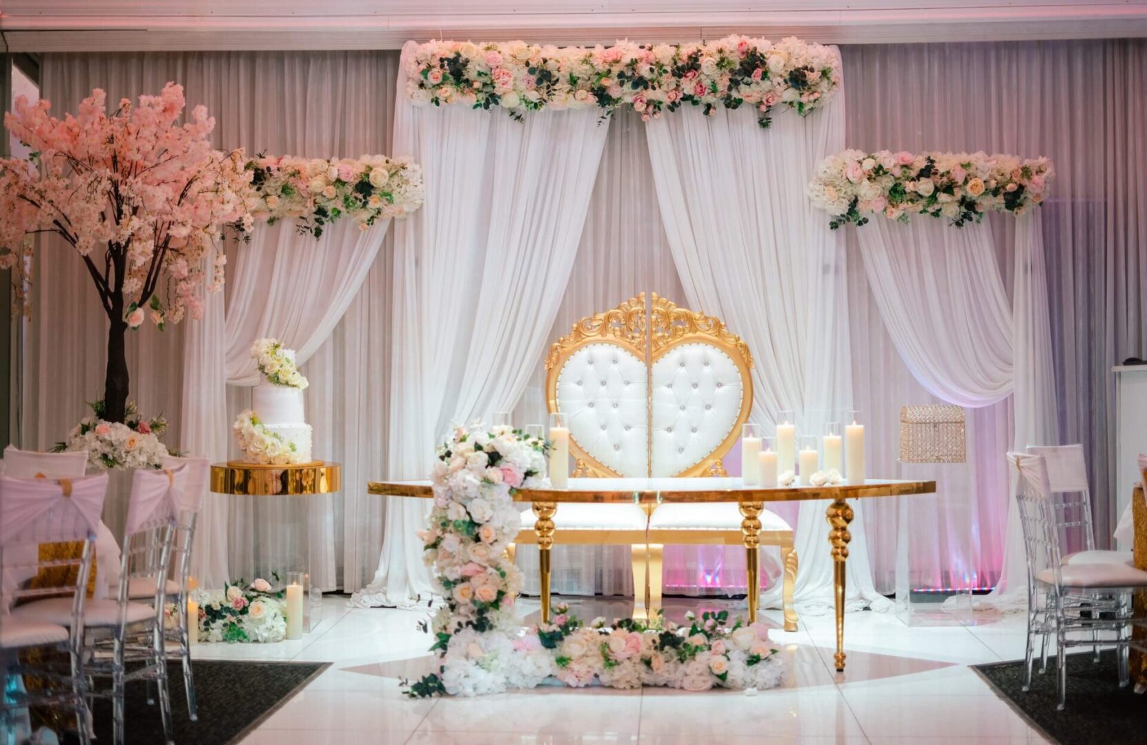 A wedding set up with flowers and white curtains.