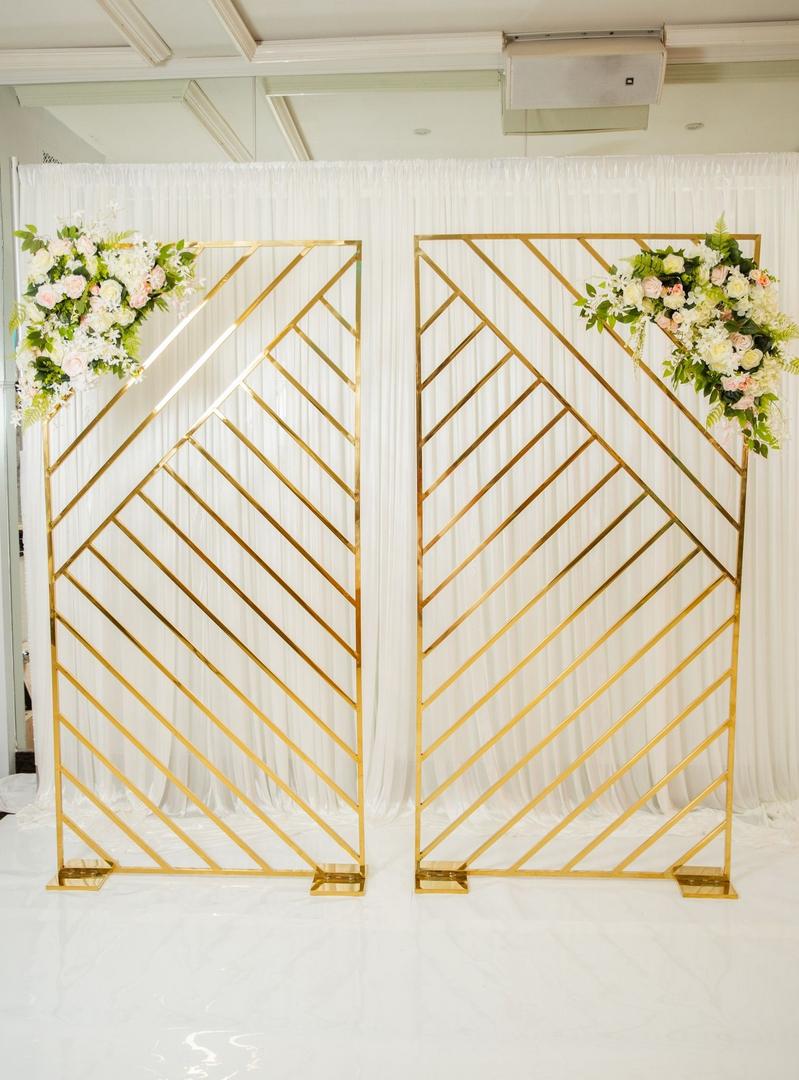 A pair of gold metal screens with flowers on them.