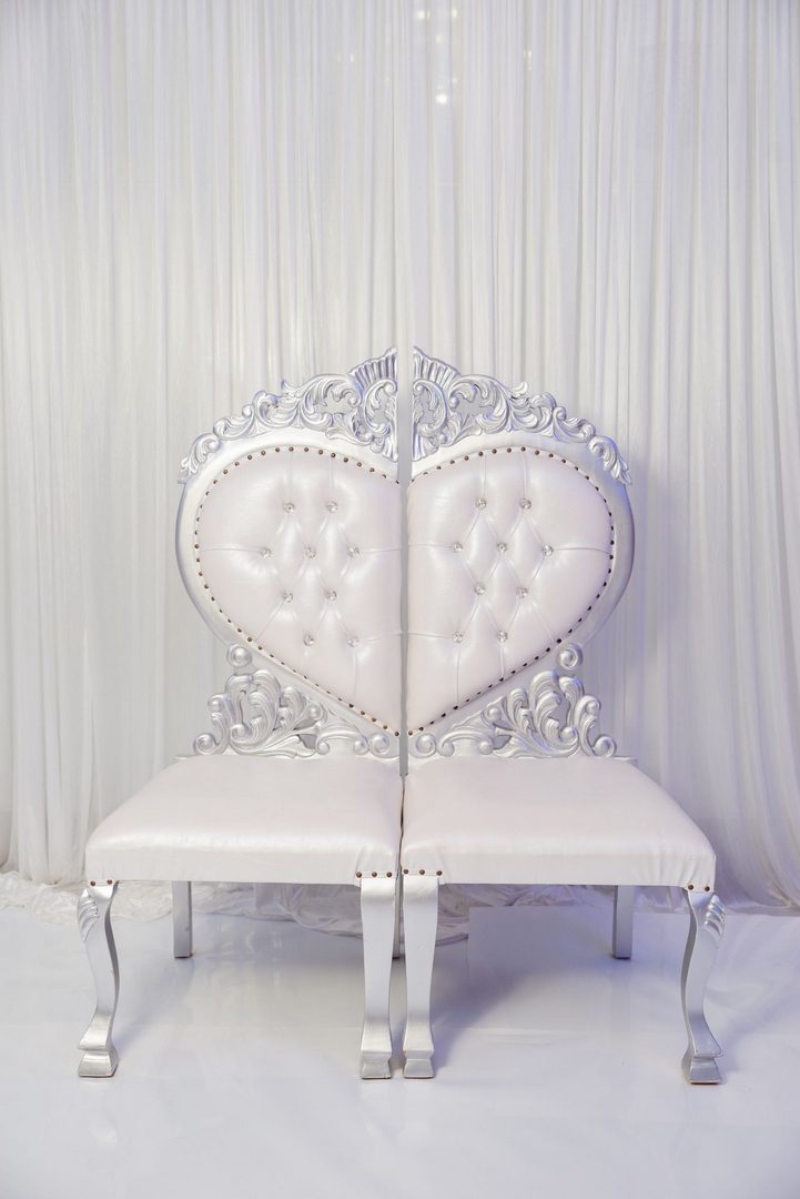 A white chair with a heart shaped back.