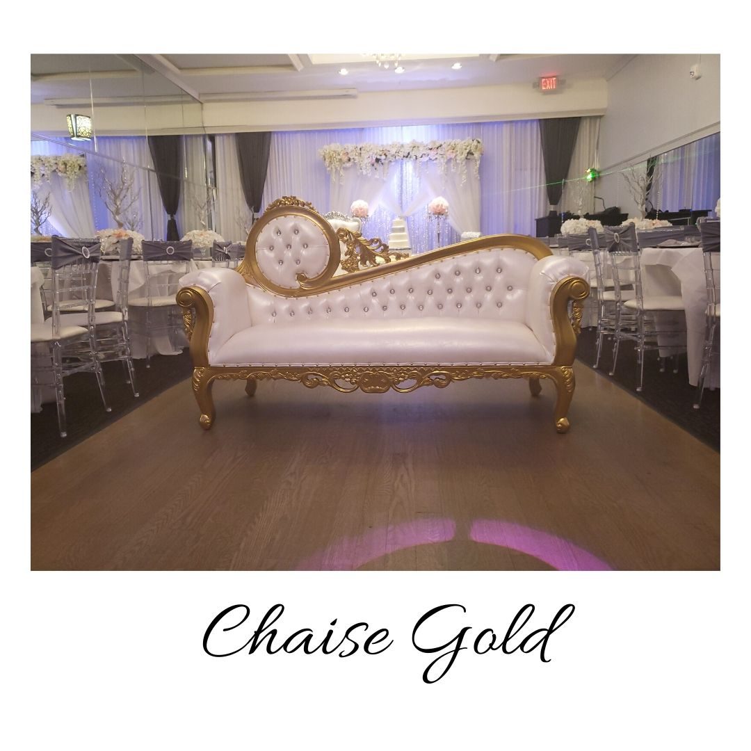 A gold couch with a clock on the back of it.