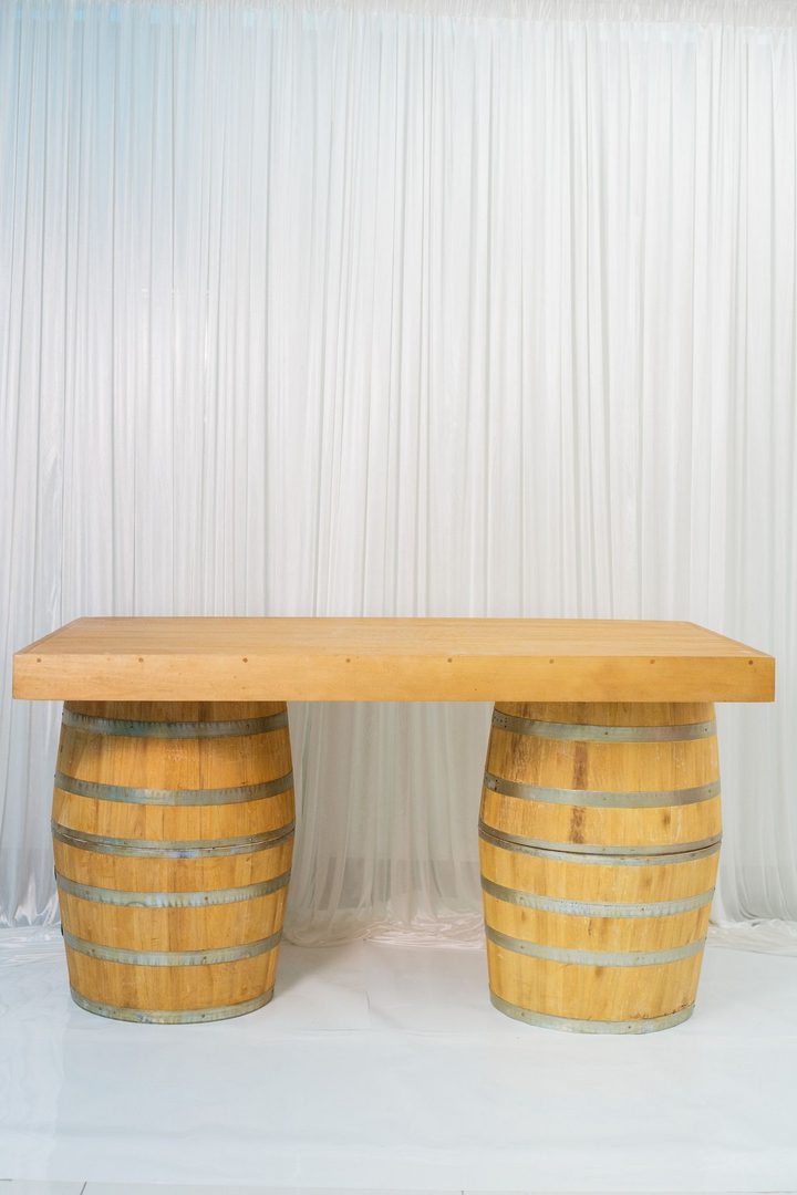 A table made out of barrels with a wooden top.