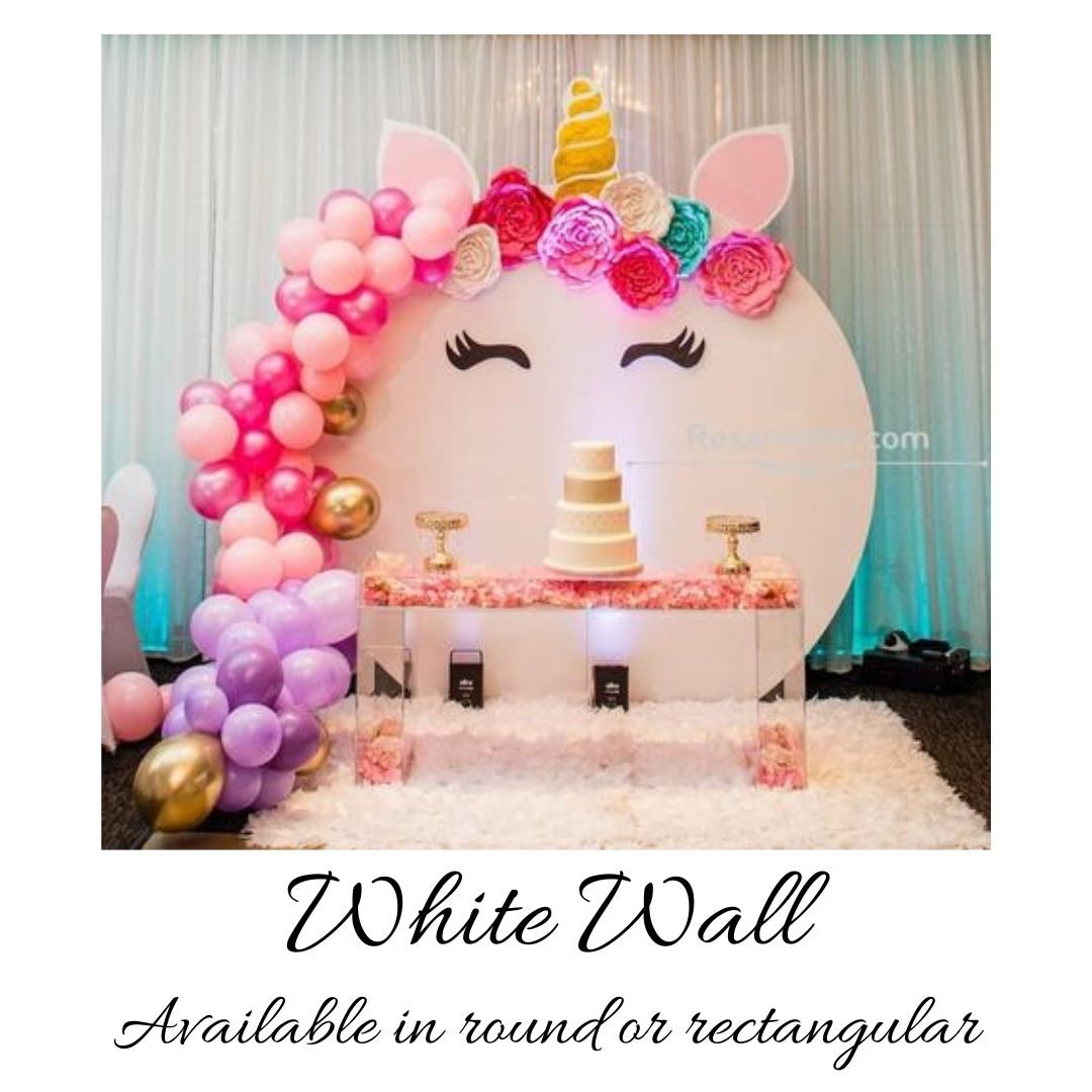 A white wall with balloons and flowers on it